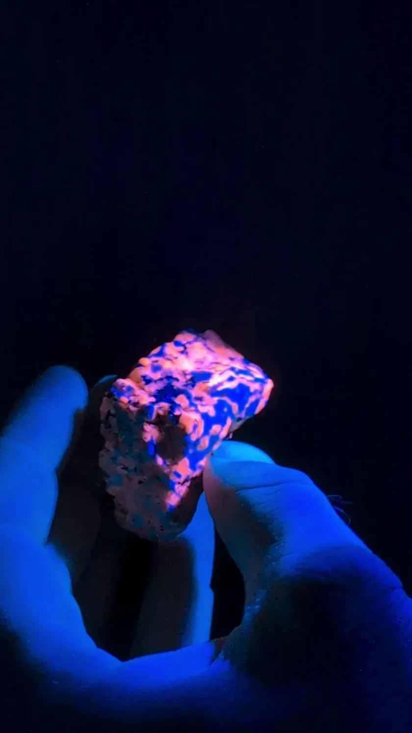 Observación de una muestra de roca bajo luz violeta