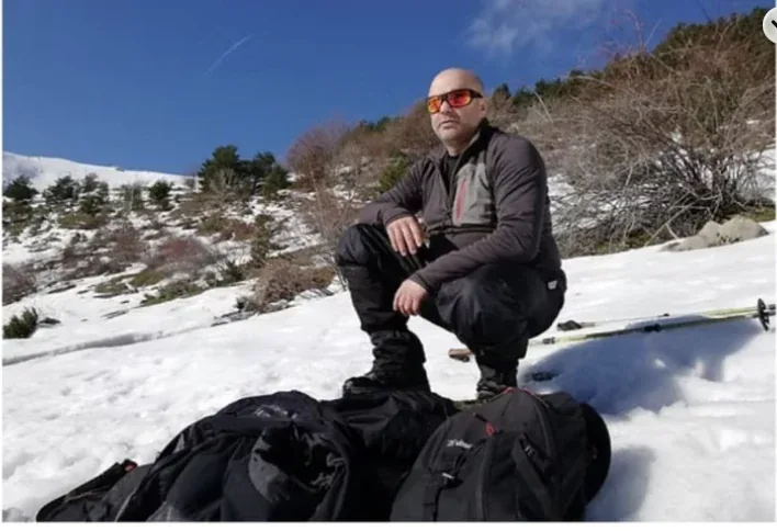 Gato en la montaña con nieve y material de expedición